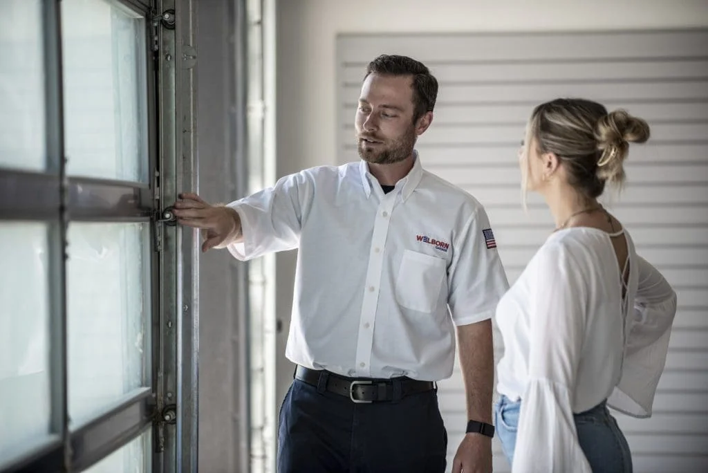 Welborn Professional Technician Helping customer in front of garage door